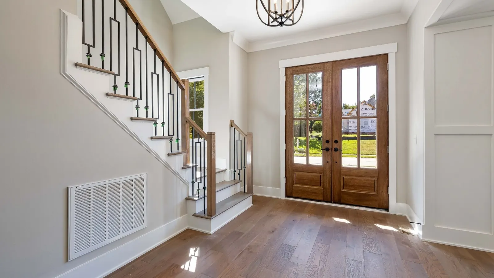 Residential foyer with clean floors and staircase detailing