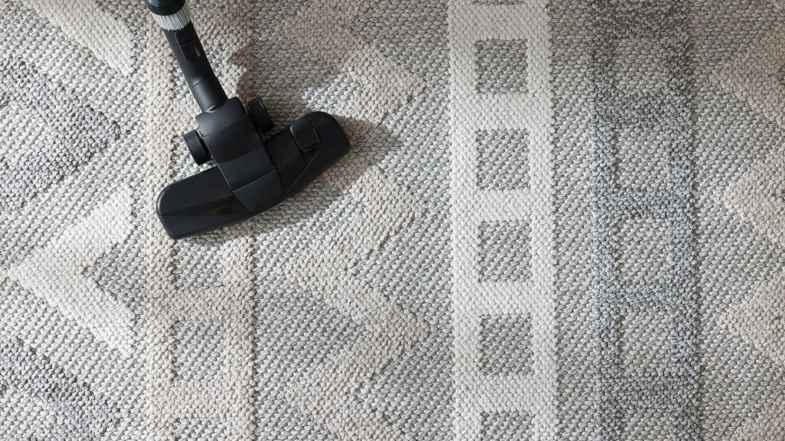 Vacuum head cleaning textured area rug in residential home
